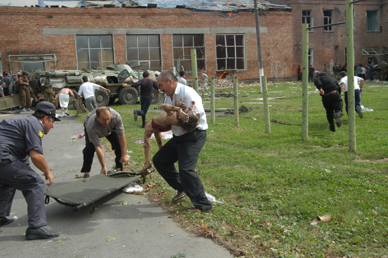 The men carry the wounded out of the gym. Beslan