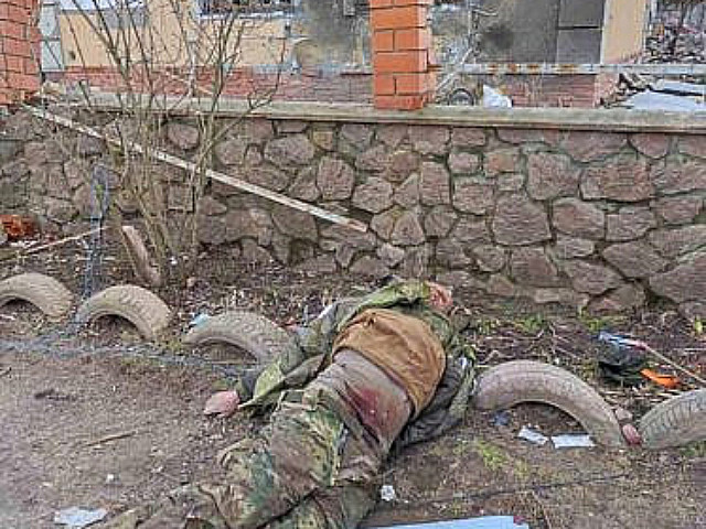 Труп российского военного на фоне разрушенного дома