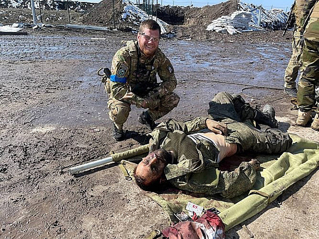 Украинский военный позирует на фоне трупа российского солдата