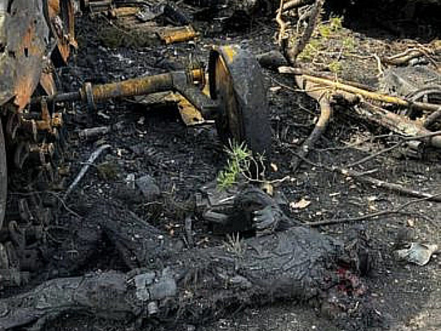 Обгоревший труп на фоне сгоревшей бронетехники