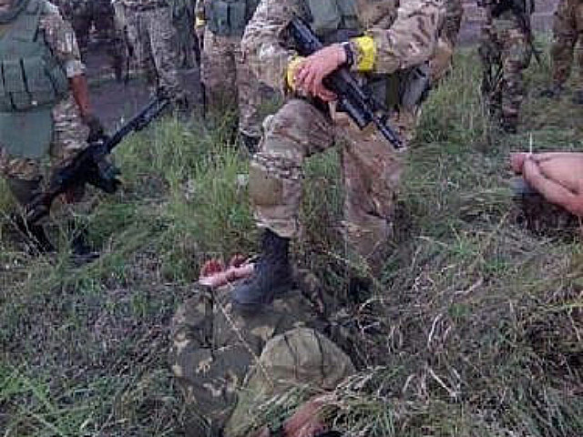 Украинский военный позирует с российским военнопленным