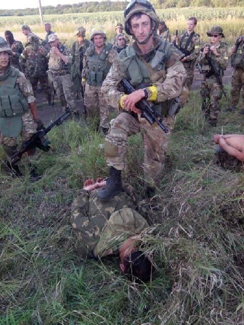 Украинский военный позирует с российским военнопленным