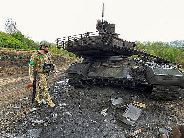 Боец ВСУ рядом с подбитым русским танком