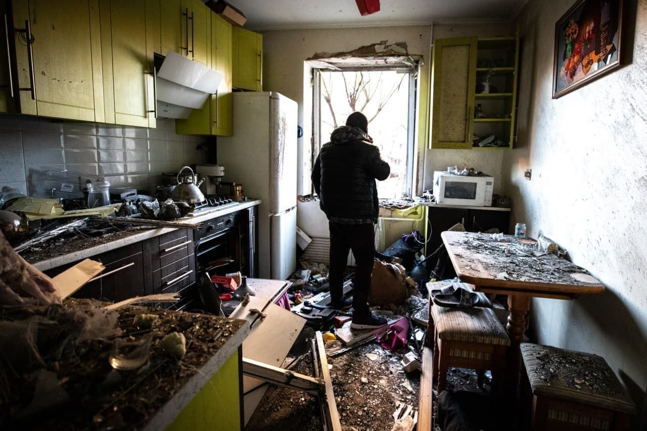 Киев. Мужчина разговаривает по телефону на разрушенной кухне